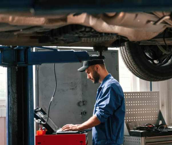 A man working on an engine in a garage.