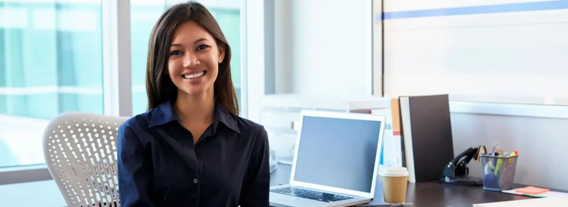 A woman sitting at her desk with a laptop.